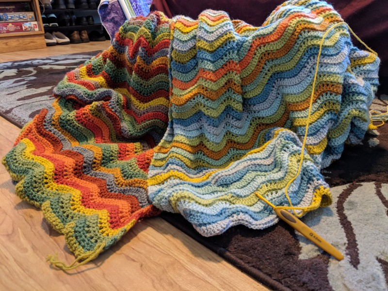 Blanket in multiple colors draped over a basket.