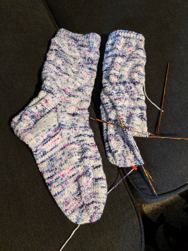 Two socks, one still being knitted, only completed up to the heel of the sock.